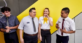 Four McDonald’s employees laughing and smiling